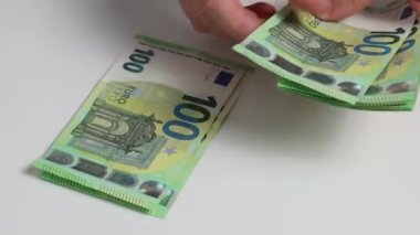 Eller, Avrupa 'nın 100 EURO parasını birbiri ardına sayar. 100 Euro 'luk banknot kapanıyor.