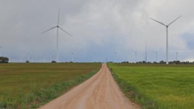 Tarımsal bir arazide kır yolu olan bir rüzgar çiftliği. Uzaklaştır.