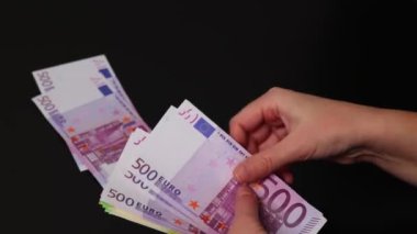 Yakın plan kadın eli farklı euro para banknotları sayar. Parayı farklı yığınlara yüzey değerine koyar.