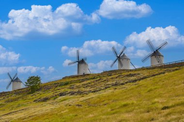 Old windmills in top of the hill in Consuegra Village. Land of the Giants and Don Quixote stories. clipart