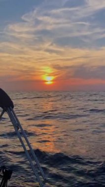 Günbatımında yelkenli bir yattan deniz manzarası