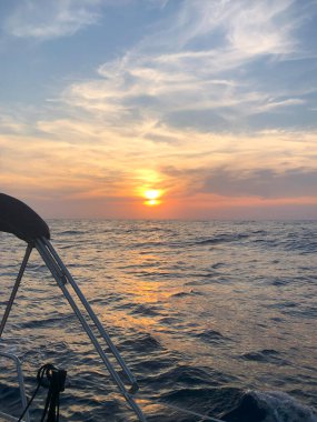 Günbatımında yelkenli bir yattan deniz manzarası.