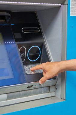 İnsan eli ATM klavyesindeki PIN koduna giriyor. Madrid, İspanya - 12 Haziran 2024.