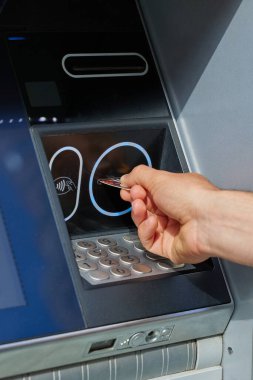 İnsan eli ATM 'ye plastik kart sokuyor. Madrid, İspanya - 12 Haziran 2024.
