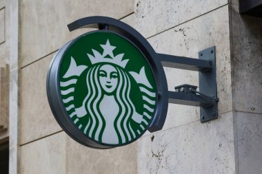 Caddenin kenarındaki Starbucks logo afişi. Madrid, İspanya - 12 Haziran 2024.