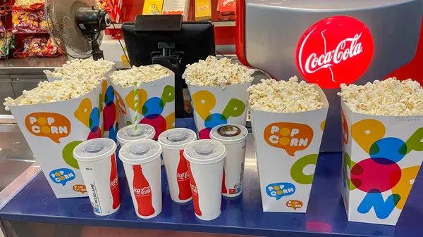 Kutularda patlamış mısır ve sinemanın tezgahındaki bardaklarda Coca Cola. Valencia, İspanya - 2 Ağustos 2024.