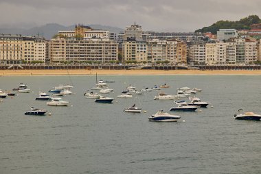 Tekneler İspanya limanındaki La Concha plajının önünde demirli. San Sebastian, İspanya - 9 Eylül 2024.
