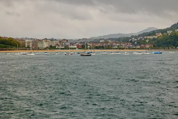 stock image Boats are moored in front of La Concha beach in the Spanish port. San Sebastian, Spain - September 9, 2024.