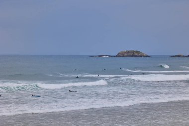 People surfing on Zurriola beach in Spanish town San Sebastian. San Sebastian, Spain - September 9, 2024. clipart