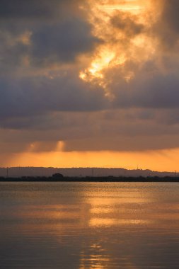 Gri bulutların ardında batan güneşin harika manzarası.