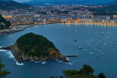 Gün batımından sonra Monte Igueldo 'dan şehrin ve Santa Clara adasının panoramik manzarası. San Sebastian, İspanya - 9 Eylül 2024.