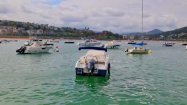 Botlar La Concha plajının önünde demirli ve Miramar Jauregia İspanyol limanında. San Sebastian, İspanya - 9 Eylül 2024.