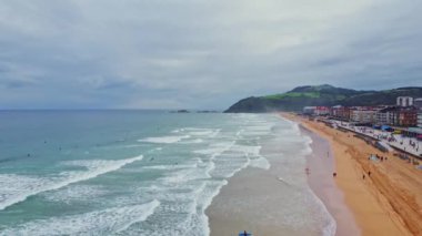 Issız sahilde sörf yapan insanların hava görüntüsü. Zarautz, Gipuzkoa, İspanya - 11 Eylül 2024.