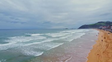 Issız sahilde sörf yapan insanların hava görüntüsü. Zarautz, Gipuzkoa, İspanya - 11 Eylül 2024.