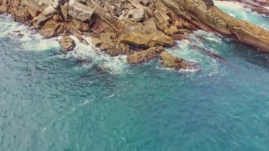 Santa Clara adasının kıyı kayalıklarında bir deniz dalgası dönüyor.