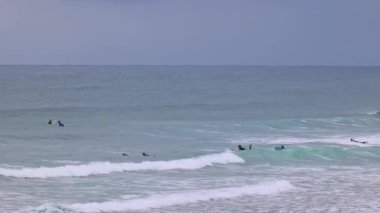 İnsanlar ıssız sahilde sörf yapıyor. Zarautz, Gipuzkoa, İspanya - 11 Eylül 2024.