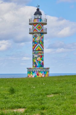 Arkasında deniz olan renkli Cabo Ajo Deniz Feneri, Bareyo. Cantabria, İspanya.