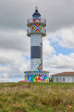 Colorful Cabo Ajo Lighthouse with sea on the background, Bareyo. Cantabria, Spain. clipart