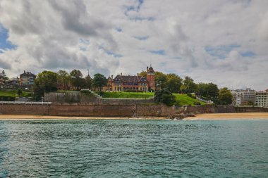 View from the water of the Miramar Palace on top of a hill in Donostia-San Sebastian, Basque Country, Spain. clipart