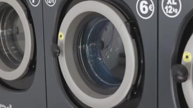 Renkli giysiler çamaşırhanedeki çamaşır makinesinde yıkanır.