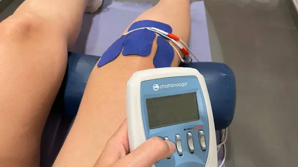 Diz için fizyoterapi. Dizinde elektro uyarıcı elektrotlar olan insan bacağı. Valencia, İspanya - 15 Kasım 2024