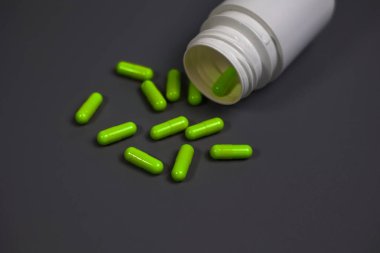 Kapsülleri dökülmüş reçeteli ilaç şişesinin yakın çekimi..