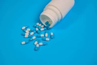 Kapsülleri dökülmüş reçeteli ilaç şişesinin yakın çekimi..