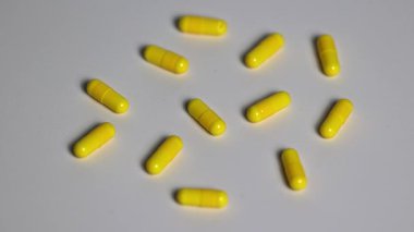 Beyaz masadaki haplarda vitamin ve ilaçlar, yakınlaştırma