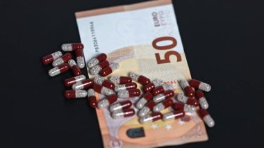 İlaç kapsüllerinin 50 avroluk banknotta rotasyonu. Avrupa 'da Sağlık Hizmetleri Maliyeti.