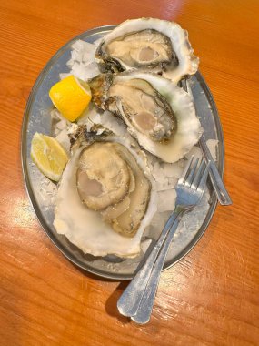 Buzlu ve limonlu bir tabakta taze açılmış Valensiyalı istiridyeler..
