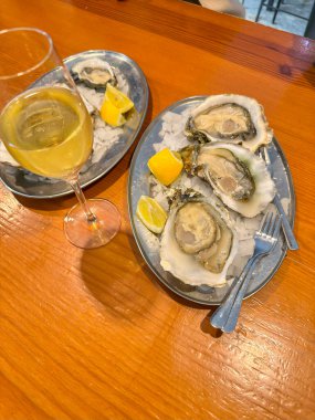 Buzlu ve limonlu bir tabakta taze açılmış Valensiyalı istiridyeler..