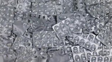 Hap kabarcıklarının üstüne düşen hapların yakın plan görüntüsü. Tedavi ve ilaç konsepti