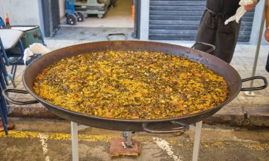 Valencia, İspanya 'daki Las Fallas Festivali sırasında geleneksel büyük bir tavada lezzetli bir paella hazırlıyor..