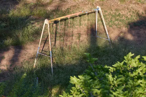 Eski paslı salıncak terk edilmiş bir yerde.