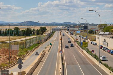 Arka planda dağlar ve trafik olan uçak otobandan görüldü. Valencia, İspanya - 11 Mayıs 2025.