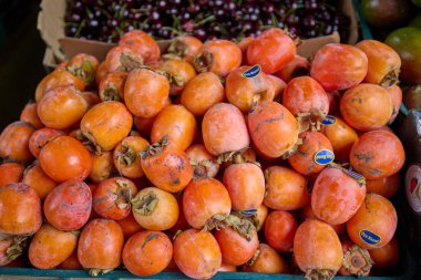Taze olgun hurmalar bir pazarda sergileniyor, canlı ve doğal, satılmaya hazır. Valencia, İspanya. 17 Mart 2025.
