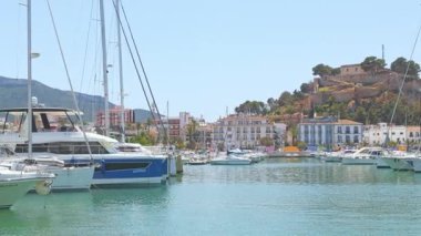 Denia marinasında arka planda tarihi Denia Kalesi 'nin yükseldiği yatların manzarası. Denia, İspanya - 31 Mayıs 2025.