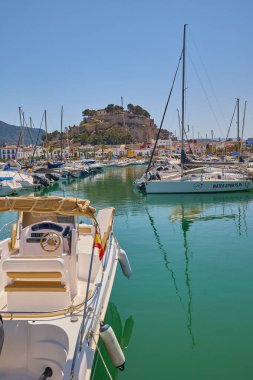 Denia marinasında arka planda tarihi Denia Kalesi 'nin yükseldiği yatların manzarası. Denia, İspanya - 31 Mayıs 2025.