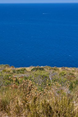 İspanya 'nın Javea kentindeki Cape Sant Antoni' deki kayalıklardan Akdeniz manzarası açık mavi su ve gökyüzü ufka kadar uzanıyor.