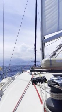 Bulutlu bir yaz gününde hareket halindeki bir yattan çekilen dikey video. Tatil ve yelkencilik
