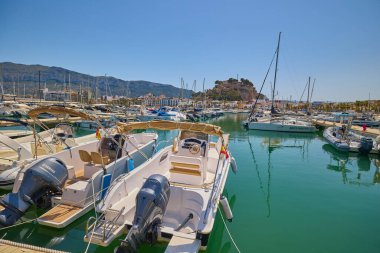 Denia marinasında arka planda tarihi Denia Kalesi 'nin yükseldiği yatların manzarası. Denia, İspanya - 31 Mayıs 2025.