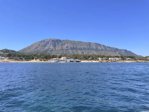 Kıyı kasabası ve dağ manzarası, güneşli bir gün..