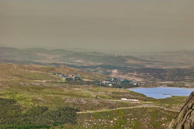 Portekiz 'in merkezindeki dağ gölü ve köy havadan görünüyor..