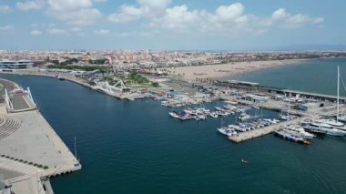 Marina Valencia 'nın çarpıcı hava görüntüsü demirli yatlar, yelkenli tekneler ve canlı şehir silueti. Valencia, İspanya - 2 Ağustos 2025.