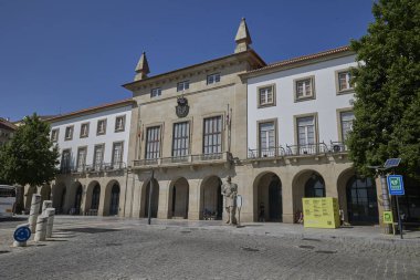 Belediye binasının önünde kemerli ve heykeli olan tarihi bir bina. Covilha, Portekiz - 22 Haziran 2025.