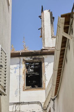 Büyük yangınlardan sonra çatısı tahrip olmuş bir ev ve pencere..