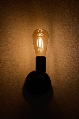 Klasik Edison tarzı duvar ampulü parlıyor.
