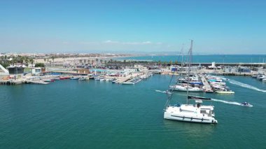 Marina Valencia 'nın çarpıcı hava görüntüsü demirli yatlar, yelkenli tekneler ve canlı şehir silueti. Valencia, İspanya - 2 Ağustos 2025.