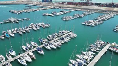 Marina Valencia 'nın çarpıcı hava görüntüsü demirli yatlar, yelkenli tekneler ve canlı şehir silueti. Valencia, İspanya - 2 Ağustos 2025.