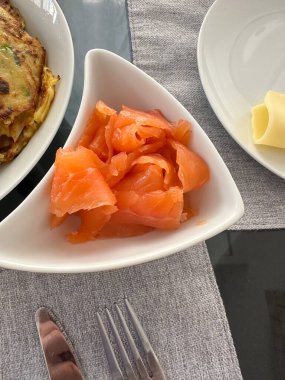 Beyaz kasede taze tütsülenmiş somon dilimleri.